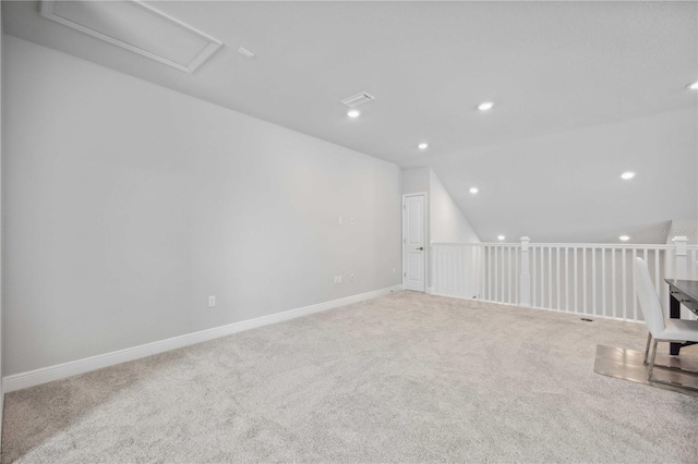 additional living space with light colored carpet and vaulted ceiling