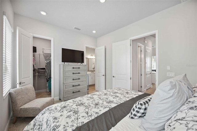 carpeted bedroom with connected bathroom, a closet, and a spacious closet