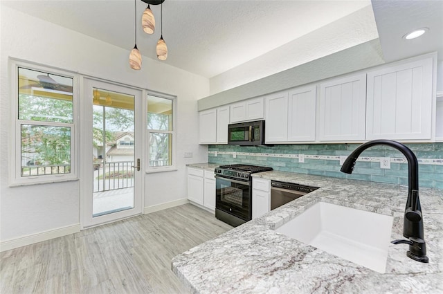 kitchen with gas stove, decorative light fixtures, white cabinetry, sink, and stainless steel dishwasher