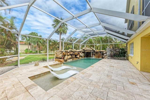 view of swimming pool with a patio, glass enclosure, and pool water feature