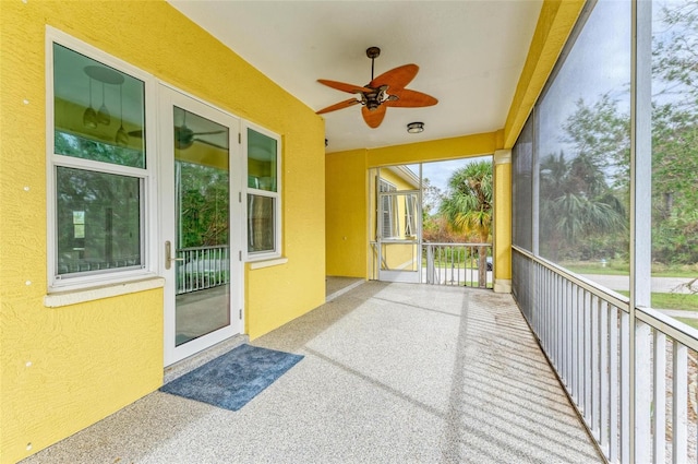 unfurnished sunroom featuring ceiling fan