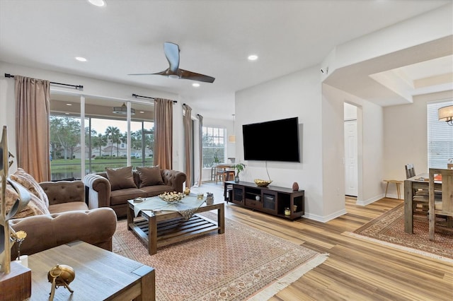 living room featuring ceiling fan and light hardwood / wood-style flooring