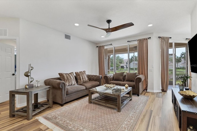 living room featuring light wood-type flooring and ceiling fan