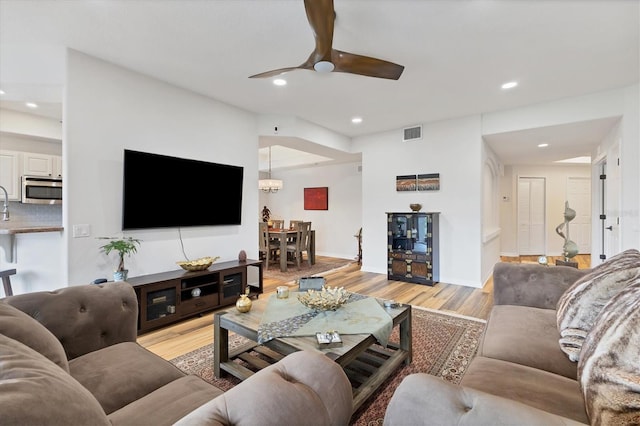 living room with ceiling fan and light hardwood / wood-style floors