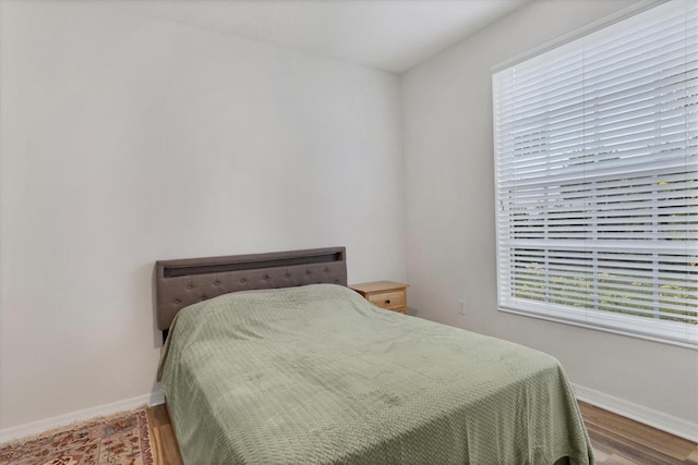 bedroom with wood-type flooring and multiple windows