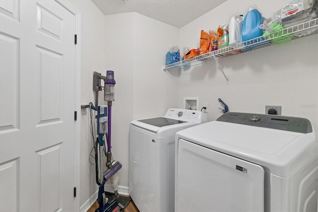 laundry area with hardwood / wood-style floors, a textured ceiling, and washer and dryer