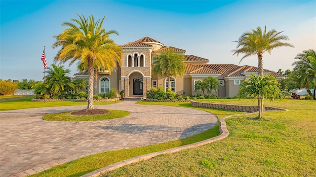 mediterranean / spanish home with a front lawn