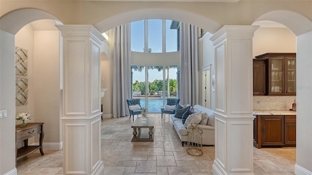 interior space with decorative columns and crown molding