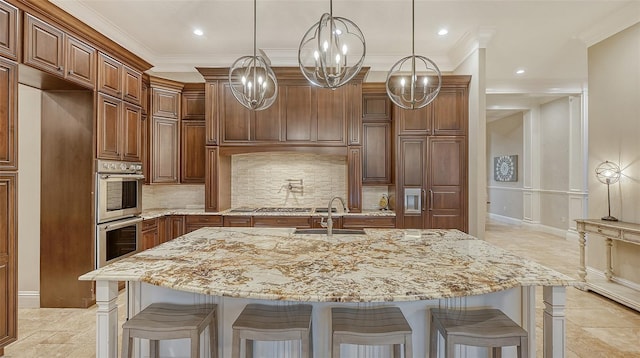 kitchen with sink, light stone countertops, a breakfast bar area, double oven, and a large island