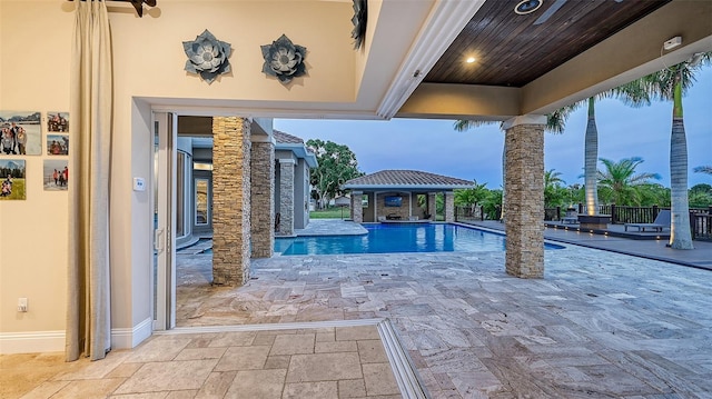 pool at dusk with a patio and a gazebo