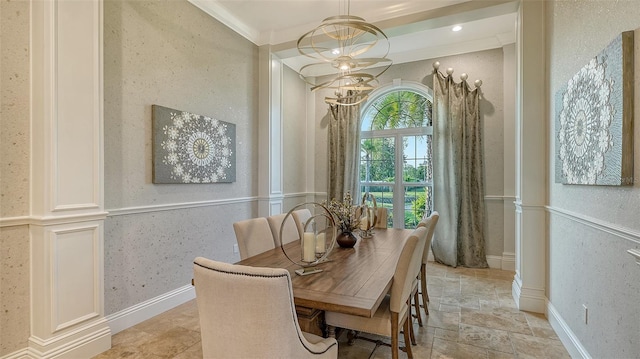 dining space featuring a chandelier, crown molding, and decorative columns