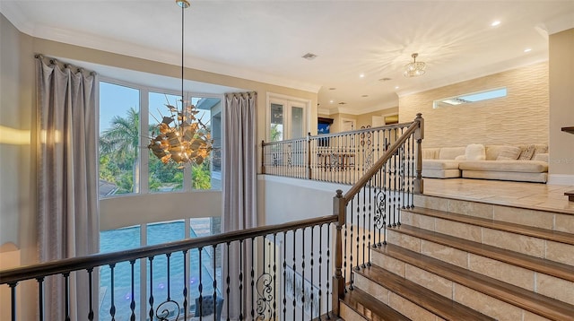 stairs featuring a chandelier and crown molding