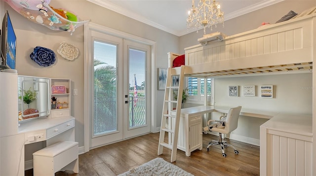 office space with light hardwood / wood-style floors, built in desk, ornamental molding, an inviting chandelier, and french doors