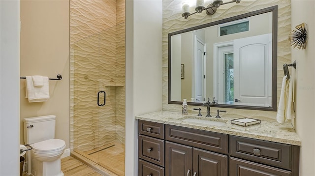 bathroom featuring toilet, vanity, hardwood / wood-style floors, and a shower with shower door