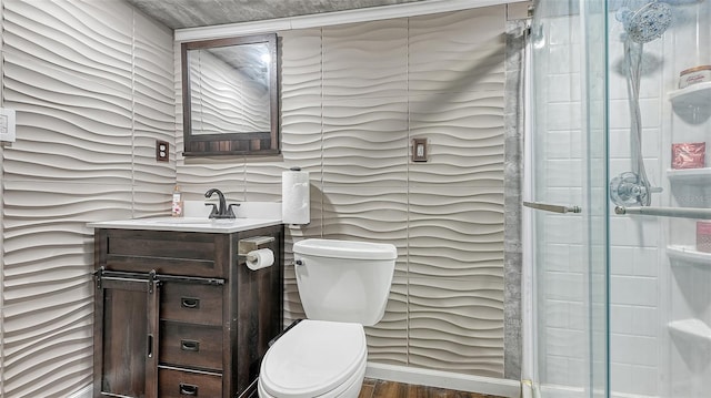 bathroom featuring toilet, an enclosed shower, vanity, and wood-type flooring