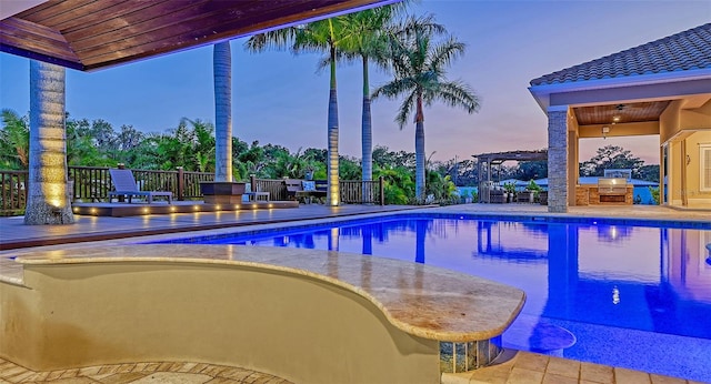 pool at dusk featuring a patio