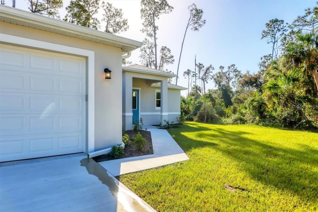 view of exterior entry featuring a lawn and a garage