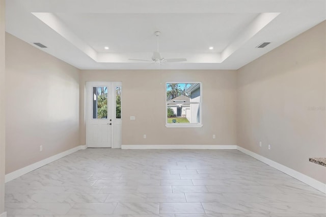 2814 Daphne Rd, North Port, FL 34288 - empty room featuring a raised ceiling, light marble finish floors, a ceiling fan, and recessed lighting