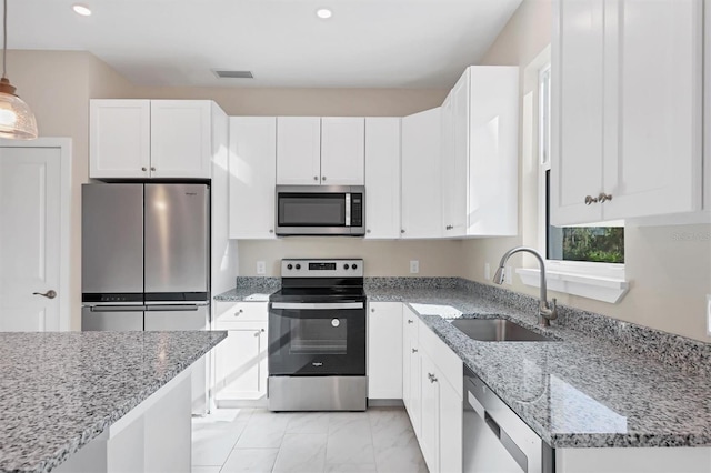 kitchen with pendant lighting, sink, white cabinetry, and stainless steel appliances