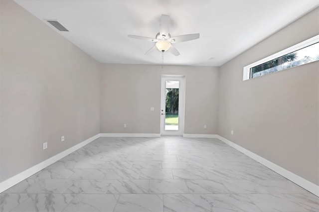 2814 Daphne Rd, North Port, FL 34288 - unfurnished room featuring marble look tile flooring, plenty of natural light, and a ceiling fan