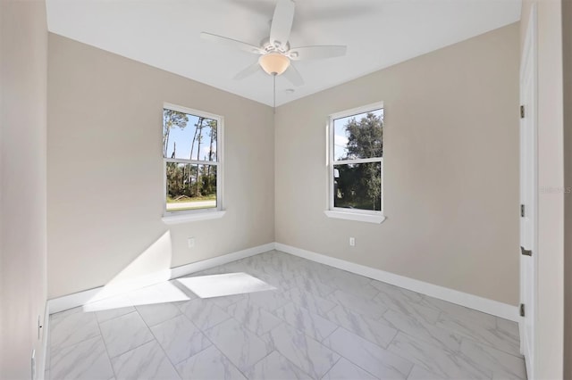 empty room with ceiling fan and a healthy amount of sunlight