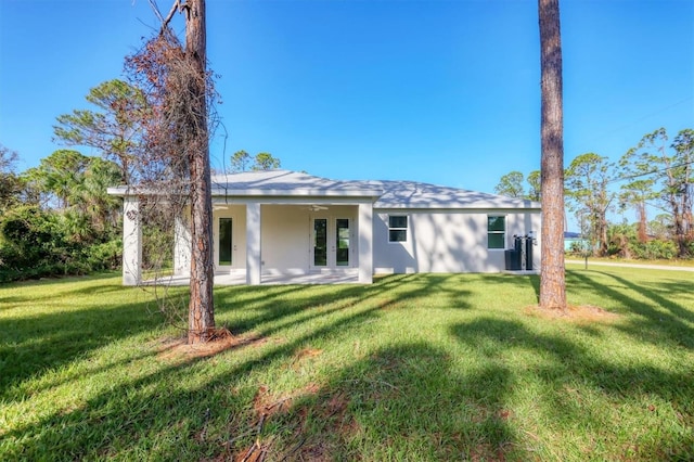 rear view of house featuring french doors, a yard, ceiling fan, and a patio area