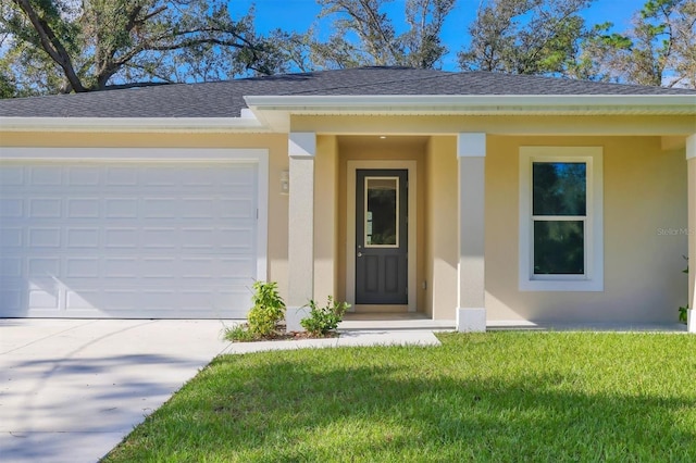 entrance to property featuring a garage and a lawn