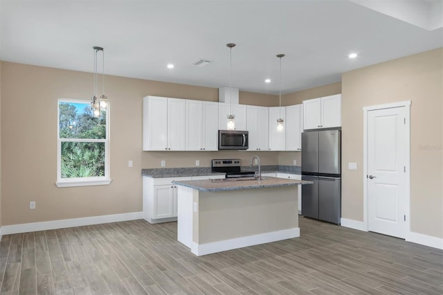 kitchen featuring white cabinetry, light wood-type flooring, a kitchen island with sink, and stainless steel appliances