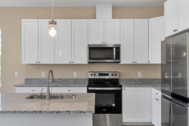 kitchen featuring white cabinetry, appliances with stainless steel finishes, hanging light fixtures, and sink