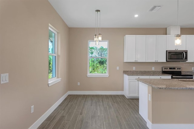 kitchen featuring stainless steel appliances, light stone counters, light wood-type flooring, white cabinets, and pendant lighting