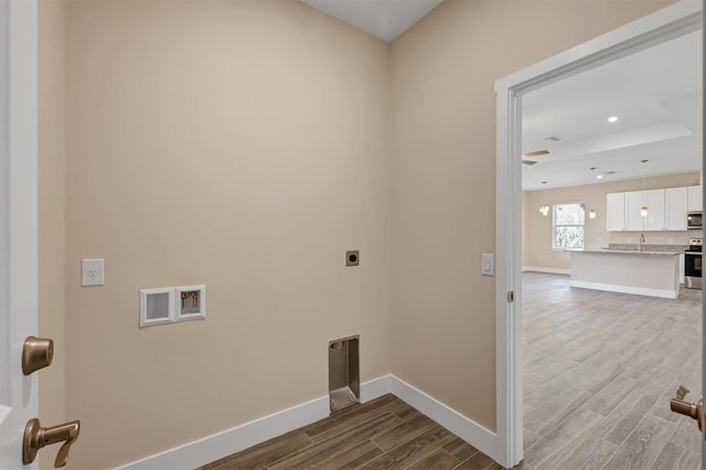 laundry room featuring hookup for an electric dryer, washer hookup, hardwood / wood-style flooring, and sink