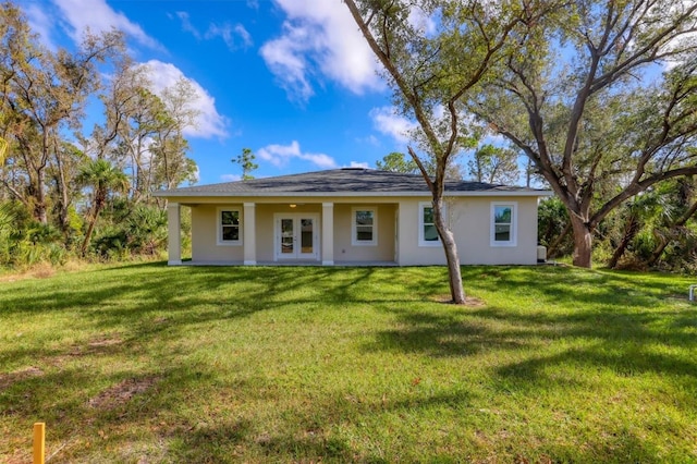 view of front of house with a front yard and french doors