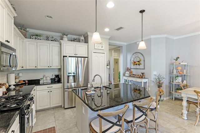 kitchen featuring a center island with sink, decorative light fixtures, appliances with stainless steel finishes, and crown molding