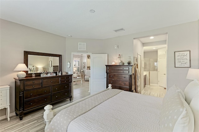 bedroom featuring light hardwood / wood-style flooring and ensuite bath