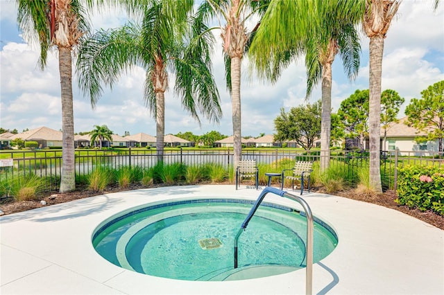 view of pool with a water view and a hot tub