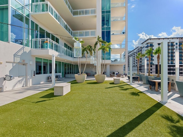 view of property's community with a patio area and a yard