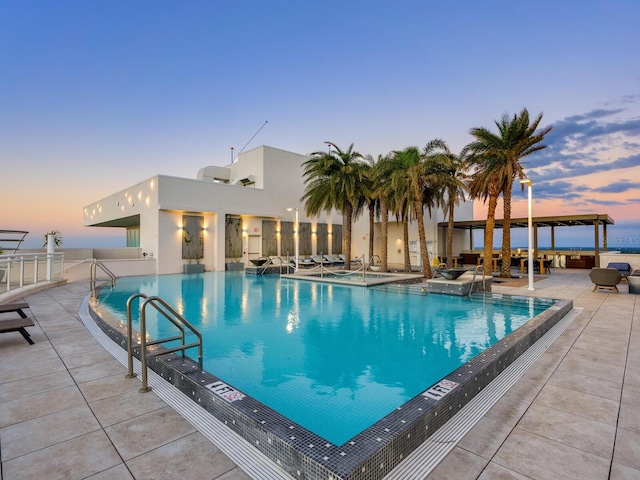 pool at dusk with a patio