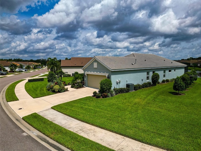 ranch-style house featuring a garage, a front lawn, and central air condition unit