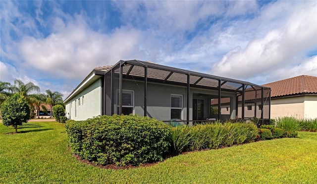 back of house with a lawn and a lanai