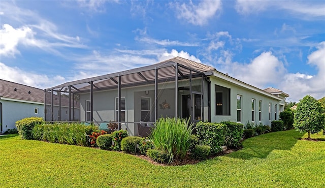 view of home's exterior with a lawn and glass enclosure