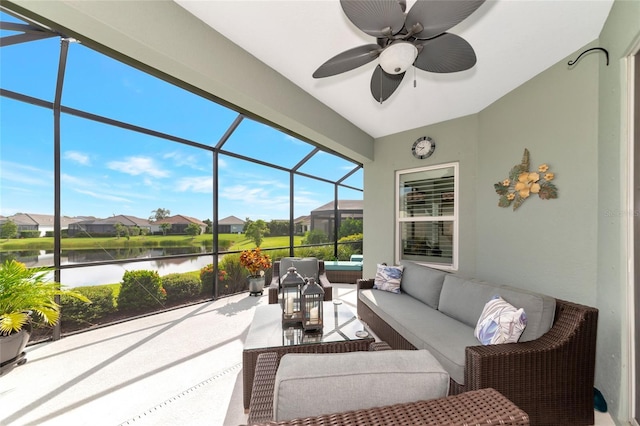 sunroom with ceiling fan and a water view