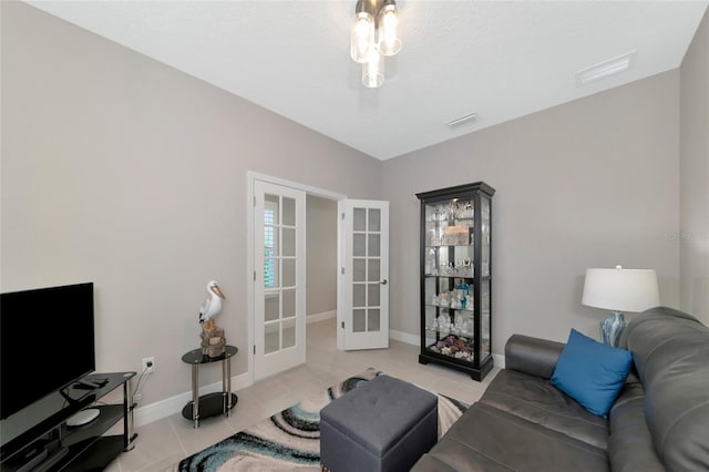 living room featuring light tile patterned floors, a textured ceiling, and french doors