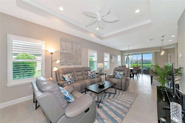 living room featuring ceiling fan, a raised ceiling, light tile patterned floors, and ornamental molding