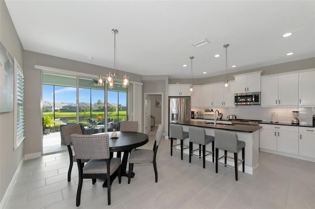 dining space with a chandelier, light tile patterned floors, and sink