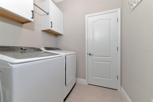 washroom featuring washer and clothes dryer, light tile patterned flooring, and cabinets