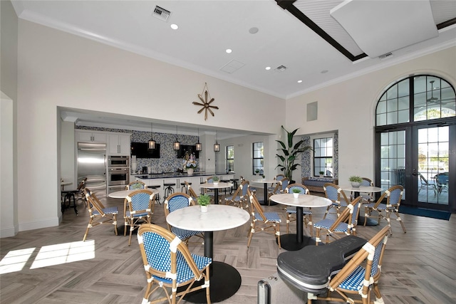 dining area with plenty of natural light, crown molding, and a high ceiling