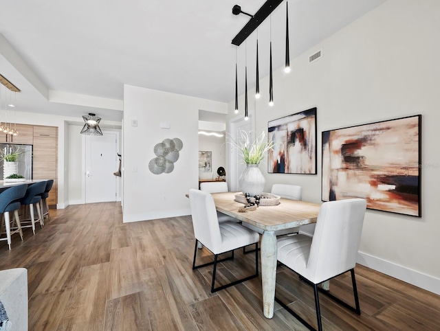 dining room with wood-type flooring and a notable chandelier