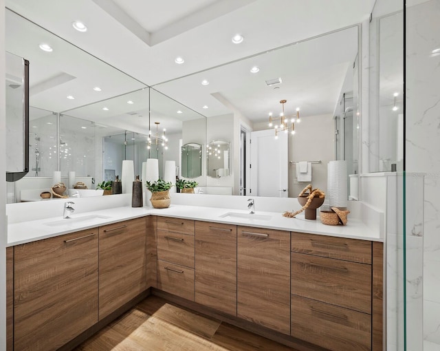 bathroom with hardwood / wood-style floors, an enclosed shower, vanity, and a chandelier