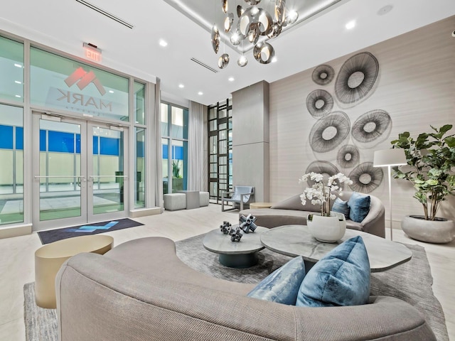 living room with expansive windows, a chandelier, and french doors