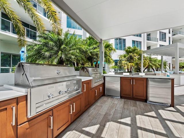 view of patio with an outdoor kitchen, a grill, and sink